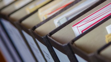 ثمانية مجلدات مملوءة بالعديد من المستندات، معروضة من الأعلى.