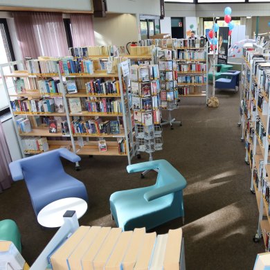 Просторна стая с рафтове за книги и места за сядане в обществената библиотека в Нидер-Роден.