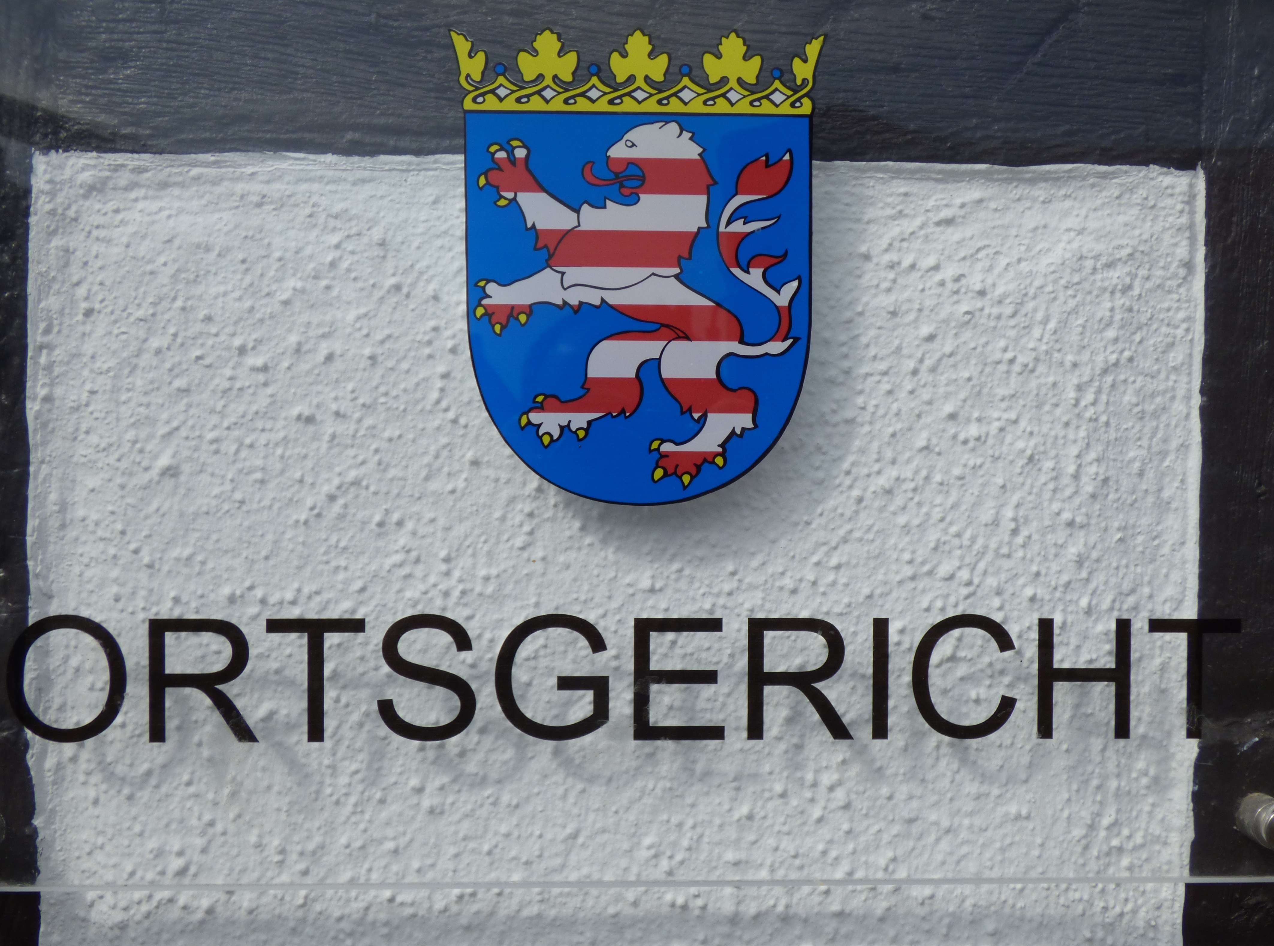 Герб с лъв и корона над надписа "ORTSGERICHT" в Dudenhofen.