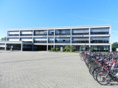 View across the schoolyard to the Heinrich Böll School building. Bicycles can be seen on the right.