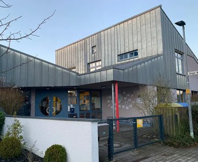 Day care centre no. 12 Exterior view of daycare centre no. 12 with modern, multi-storey wooden building and blue entrance with round windows