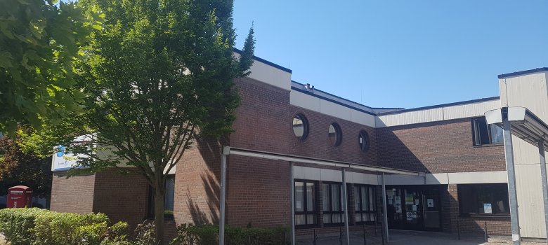 Niederroden social centre Entrance area of the Niederroden social centre with brick façade, several round windows and trees in the foreground