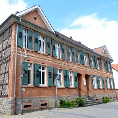 A red brick building with green shutters at Vordergasse 37