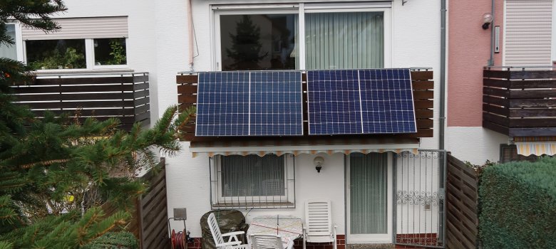 Balcony solar systems A white building with solar panels on the balcony