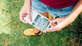 Woman in a meadow holding a plot plan in her hands
