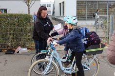 A policewoman checks children on bicycles in the school playground for their cycling licence