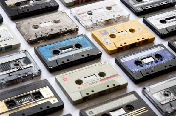 Several audio cassettes of different brands and colours, typical of the 1980s, lie next to each other