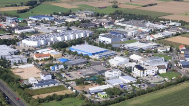 The aerial view of the industrial estate in Jügesheim shows many large and small factory, warehouse and hotel buildings framed by nearby fields.