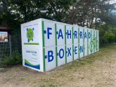 Two-storey bicycle boxes in front of the lido fence