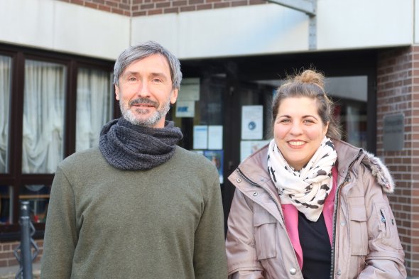 Un hombre y una mujer de pie frente a un edificio