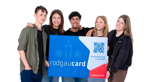 Cinco jóvenes con una gran RodgauCard Cinco jóvenes sostienen una RodgauCard azul grande con un código QR y una zona roja con el texto "rodgaucard.de".