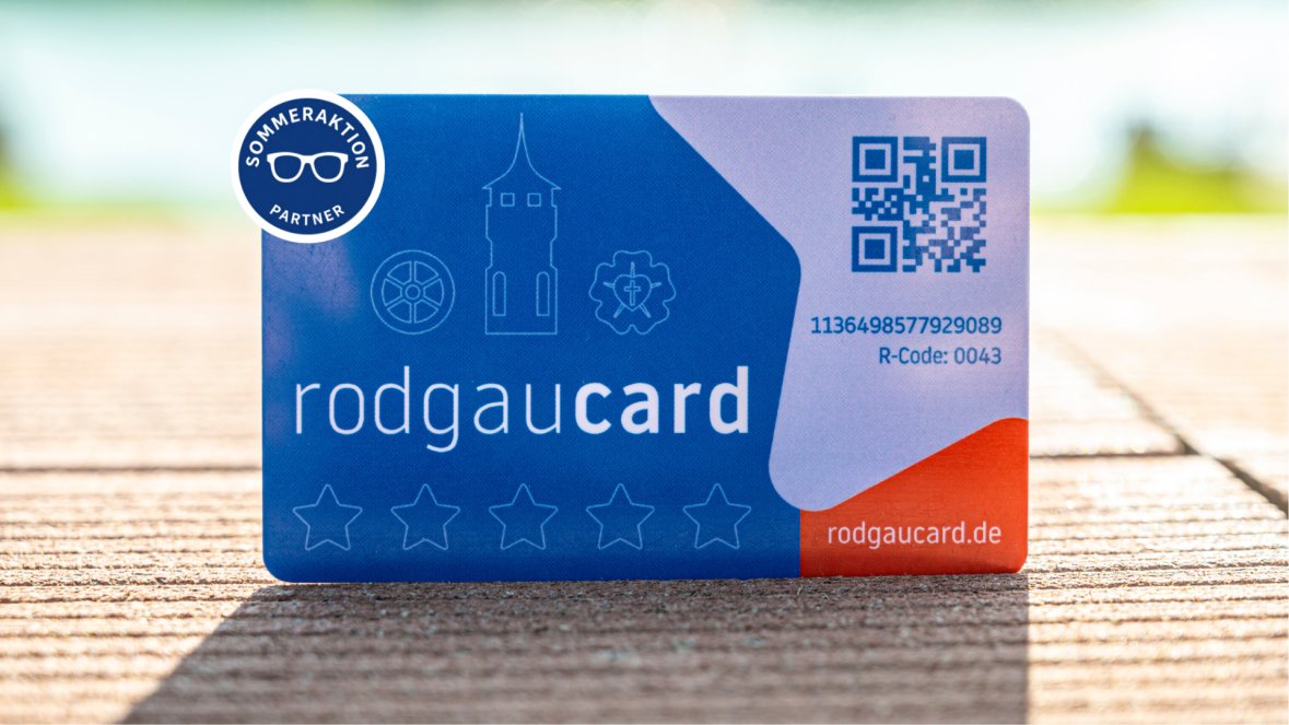 Promoción de verano de la rodgaucard Tarjetas Rodgaucards azules con texto en blanco, un código QR, símbolos y la inscripción «Promoción de verano para socios» sobre un fondo de madera