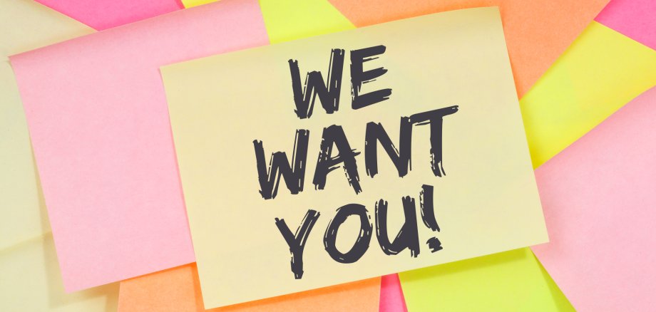 Plusieurs post-its colorés, dont un jaune avec le texte 'WE WANT YOU!' en noir.