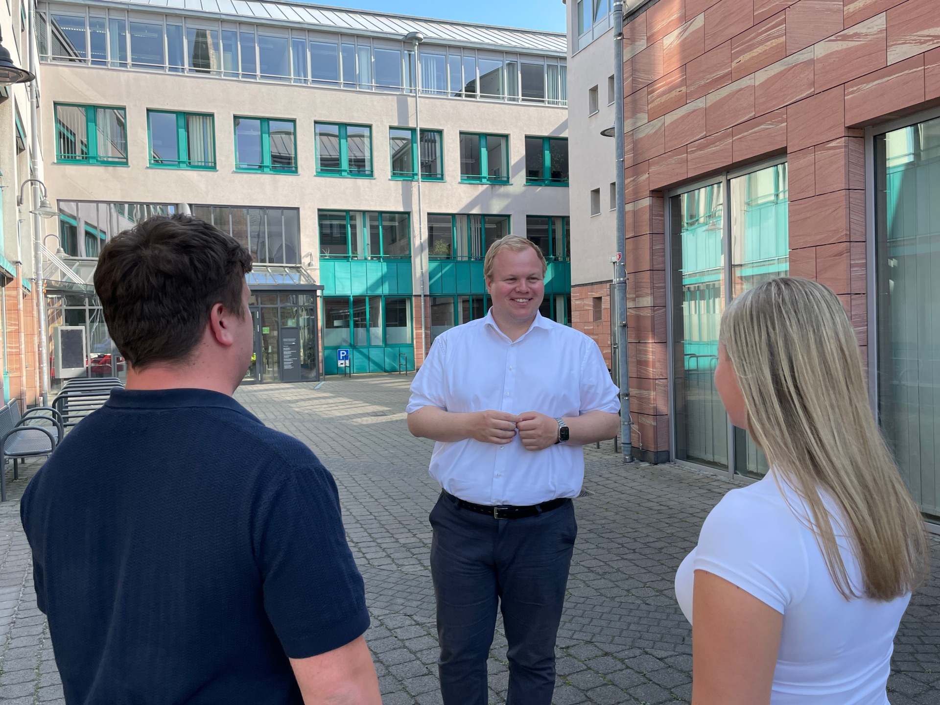 Le maire Max Breitenbach s'entretient avec deux personnes dans la cour de l'hôtel de ville