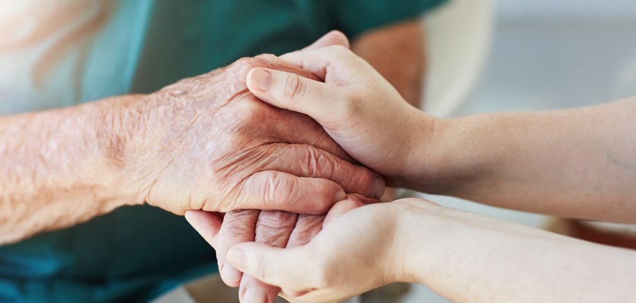 Des mains plus jeunes tiennent les mains d'une personne plus âgée.