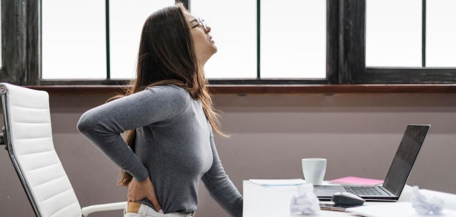 Due donne in abbigliamento sportivo. La donna a sinistra indossa una maglietta nera e dei leggings con un motivo viola. La donna a destra indossa un top nero e leggings neri, con scarpe rosa. La donna a sinistra sostiene la donna a destra, che è in piedi in una posa sportiva.