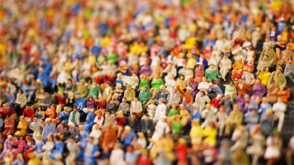 Numerose figure in miniatura colorate e ravvicinate, esposte ad una mostra d'arte