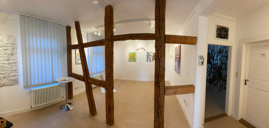 Interno della Galleria di Rodgau con pareti bianche, diverse opere d'arte alle pareti e una struttura in legno a graticcio al centro