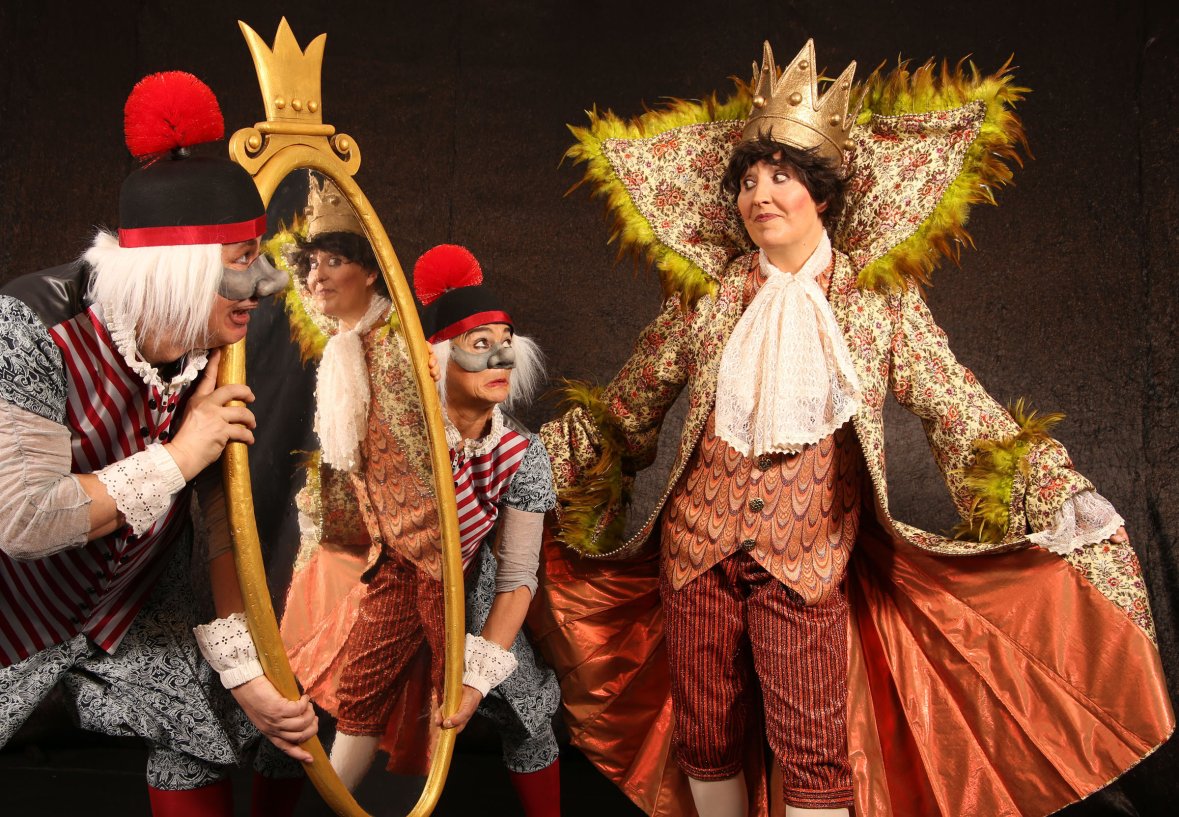 Tre persone in costume con trucco da clown, raffigurate in una scena teatrale