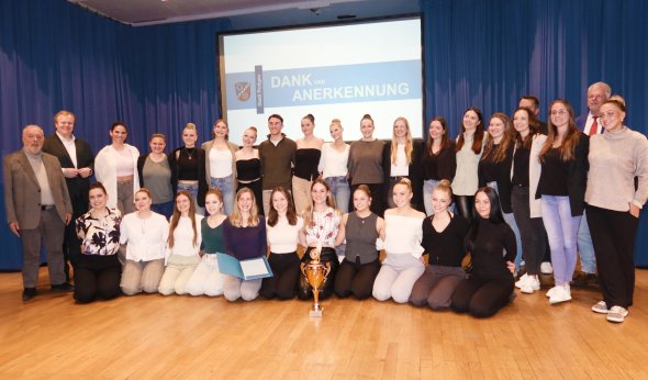 Un gruppo di persone posa per una foto davanti a uno schermo al gala del club