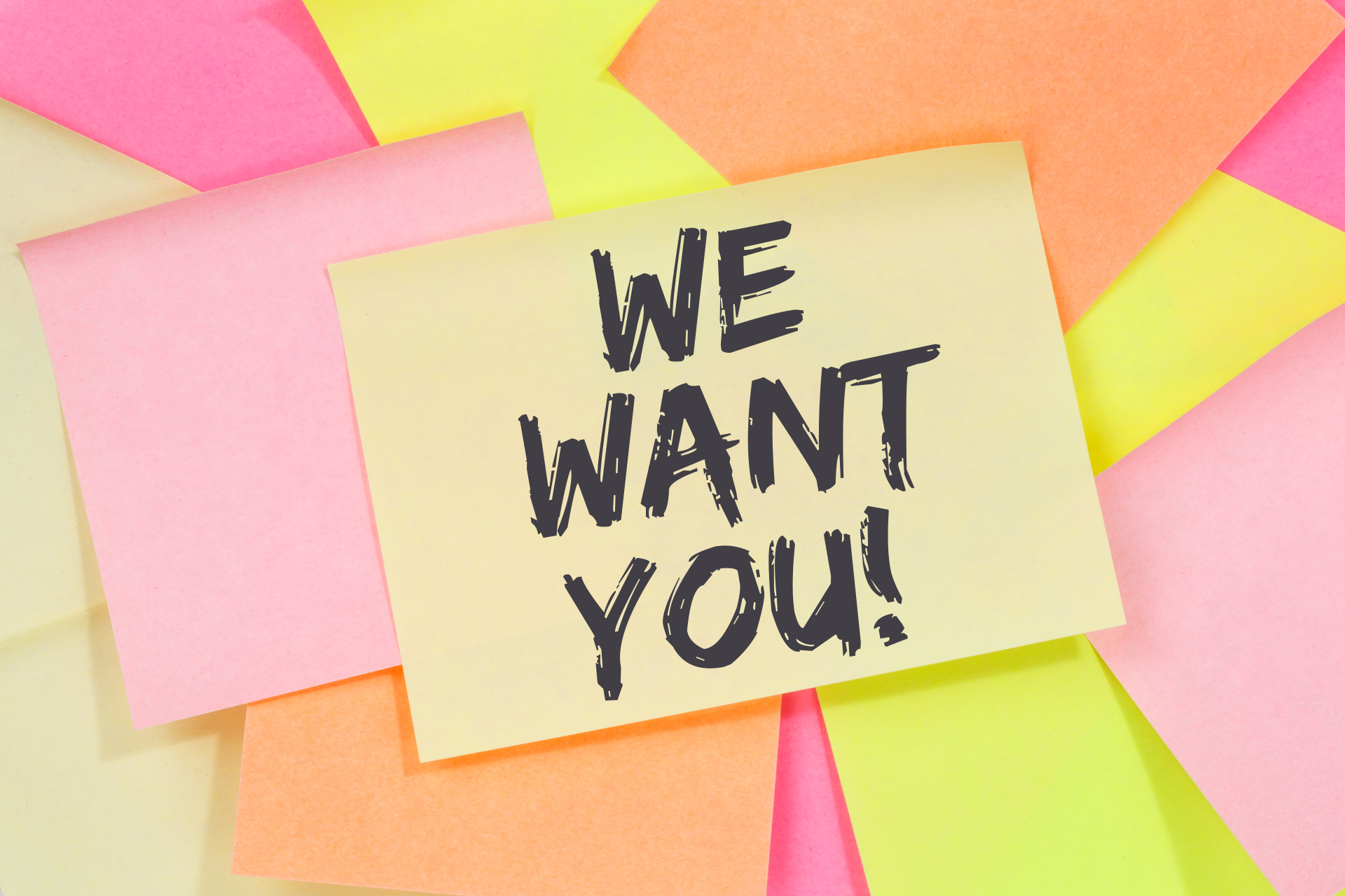 Kilka kolorowych karteczek samoprzylepnych, w tym żółta z czarnym napisem "WE WANT YOU!".