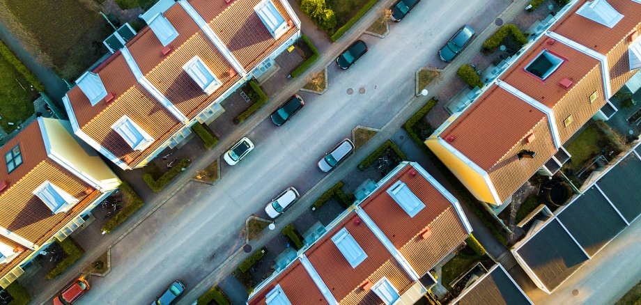 Widok z lotu ptaka na domy szeregowe, ulicę i zaparkowane samochody