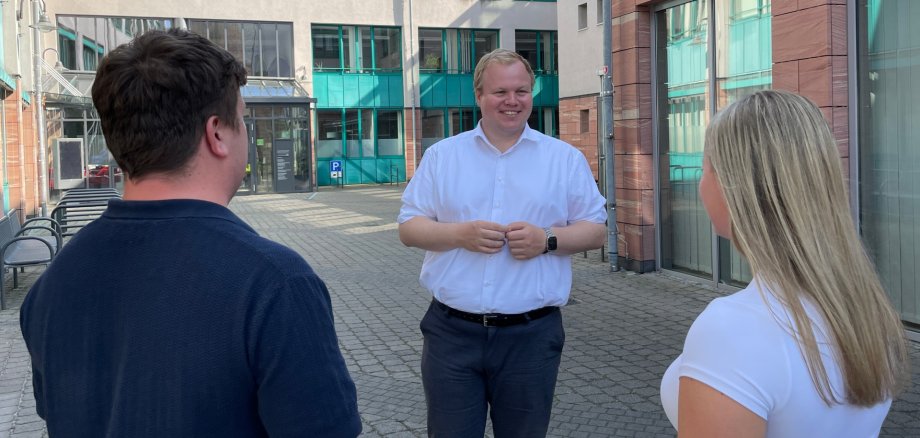 O Presidente da Câmara Max Breitenbach com duas pessoas no pátio O Presidente da Câmara, Max Breitenbach, fala com duas pessoas no pátio interior da Câmara Municipal