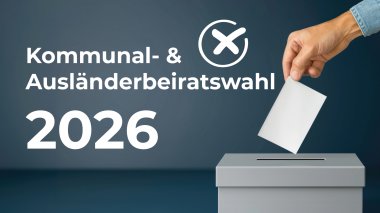 O mână aruncă buletinul de vot în urna de vot gri în fața unui fundal albastru închis cu textul "Kommunal- & Ausländerbeiratwahl 2026