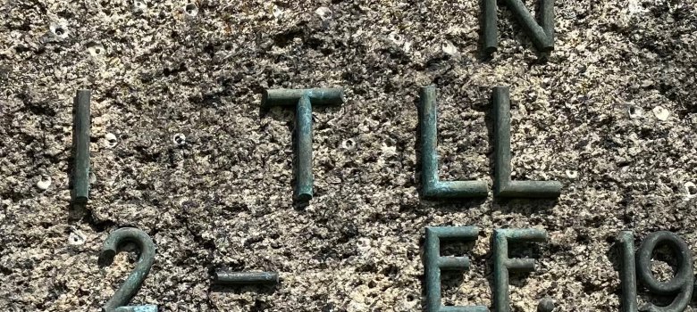 Şecere ve aile araştırması Kaba bir taş yüzey üzerine bronz harfler ve rakamlar, soy ve aile araştırmaları için tarihi bir yazıtın parçası