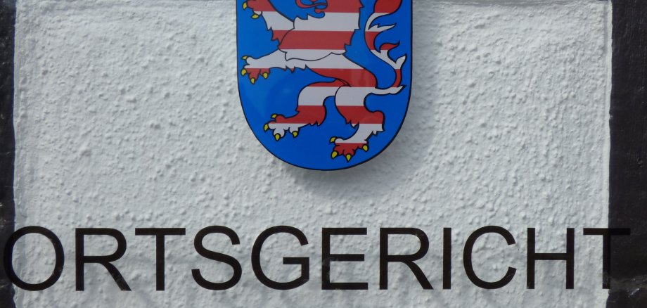 Герб з левом і короною над написом "ORTSGERICHT" у Дуденгофені.
