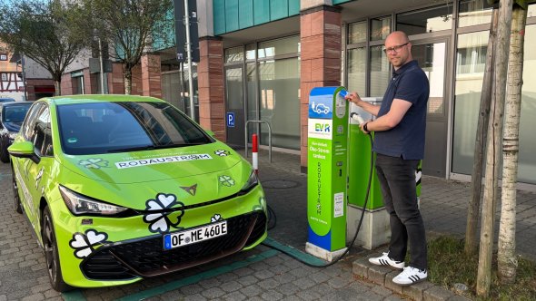 Ladestation für E-Autos Ein Mitarbeiter der Energieversorgung Rodau GmbH hat sein links stehendes E-Auto angeschlossen und startet den Ladeprozess an der Ladesäule mit einer rodgaucard.